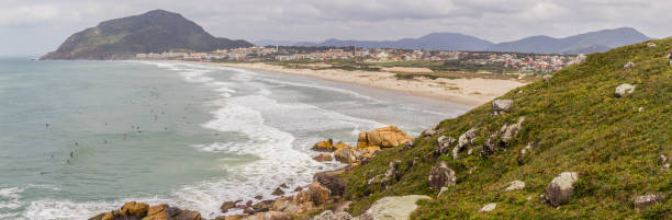 istock Panorama with Surfers in Costao do Santinho beach 875234676