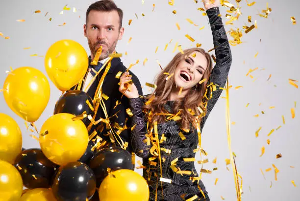 Photo of Couple dancing among falling confetti and streamer at party