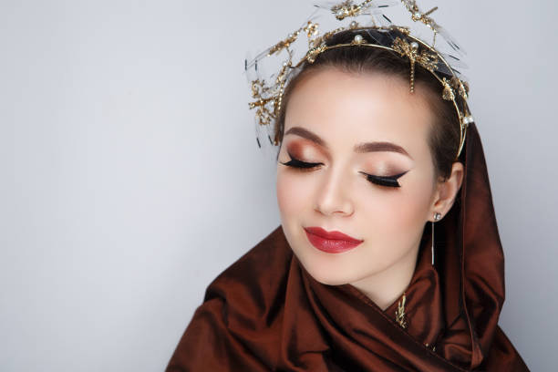 A stunning portrait with intricate metallic textures, bold makeup, and a confident gaze, embodying timeless elegance.