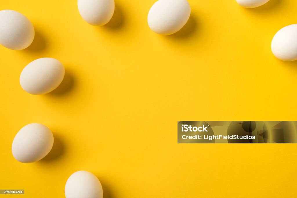 Uncooked Chicken eggs Top view of Uncooked Chicken eggs isolated on yellow Animal Egg Stock Photo