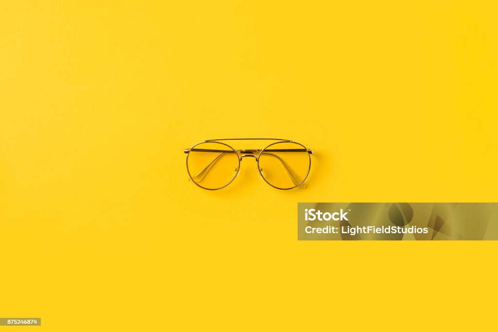 one stylish Glasses Top view of one stylish Glasses isolated on yellow Eyeglasses Stock Photo