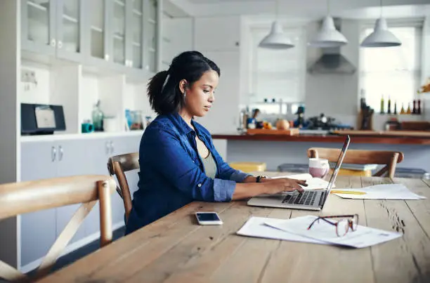 Shot of a young woman using a laptop while working from home