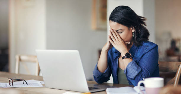 When working from home isn’t work out Shot of a young woman looking stressed while using a laptop to work from home mistake stock pictures, royalty-free photos & images