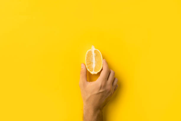 istock man holding half of lemon 875249620