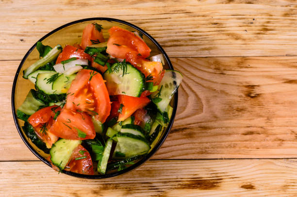 istock Salad with cucumbers and tomatoes on wooden table. Top view 875252918