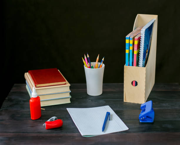 istock On the table lay a book,Notepad with pen, Cup of pencils, hole punch, stapler, notebook. 875254124