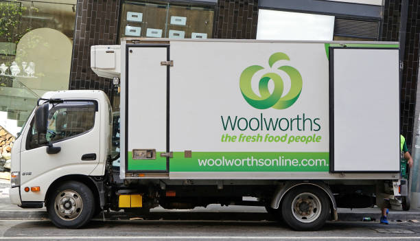 camião de marca de uma cadeia de supermercados australiano conhecido woolworths está fazendo uma entrega de mercearia - known how - fotografias e filmes do acervo