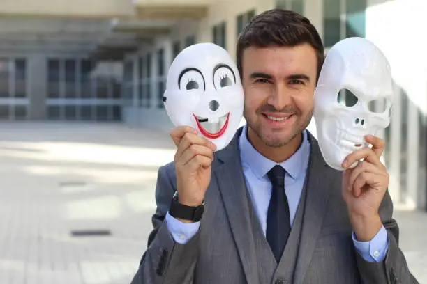 Photo of Fishy businessman holding scary masks isolated