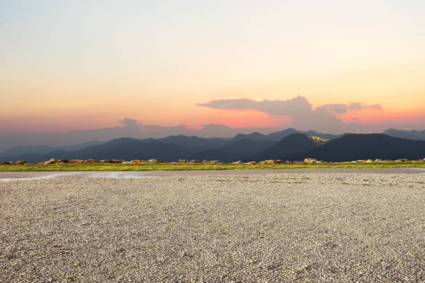 empty dirt floor with green mountains at twilight