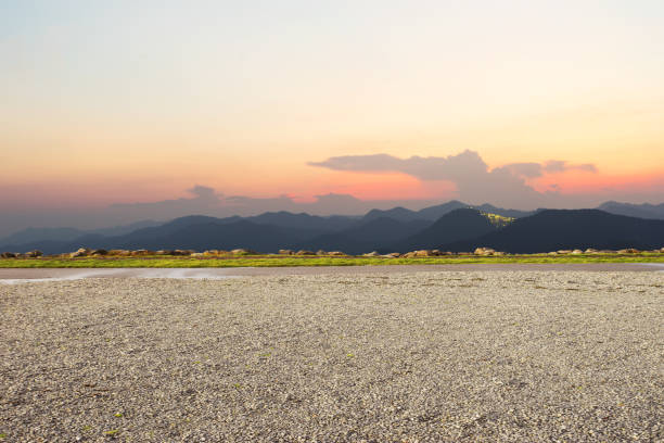 empty dirt floor with green mountains at twilight stock photo