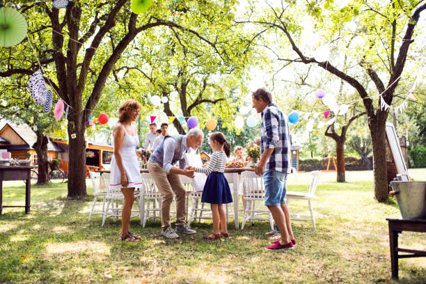 Family celebration or a garden party outside in the backyard. Family celebration outside in the backyard.Big garden party. Birthday celebration. garden parties stock pictures, royalty-free photos & images