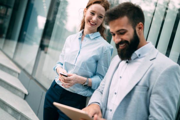 istock Business couple using digital tablet in front of office 875265770