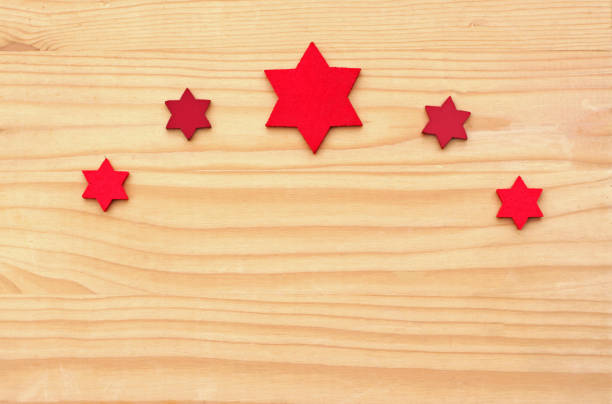 Christmas background, bow of red felt stars on wooden table