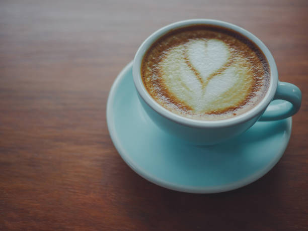 istock Coffee cup heart-shaped  on wooden table at bar counter Vintage color, filter effect. 875270316