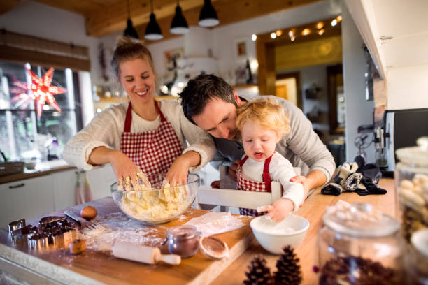 istock Young family making cookies at home. 875272740