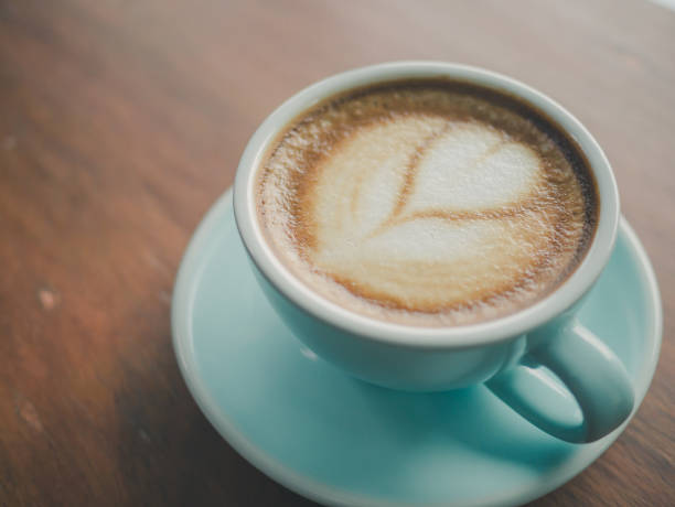 istock Coffee cup heart-shaped  on wooden table at bar counter Vintage color, filter effect. 875273878