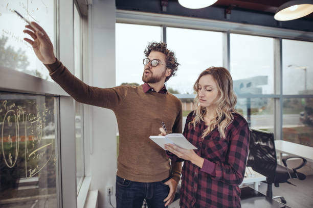 istock Two people working late in the office 875274794