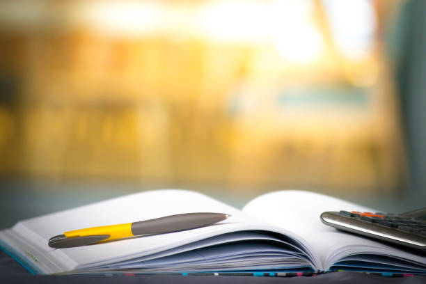 istock Notepad with pencil and calculator on blurry background.using wallpaper for education, business photo.Take note of the product for book with paper and concept, object or copy space. 875275252