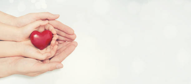 istock Parent and child holding heart in hand 875275258