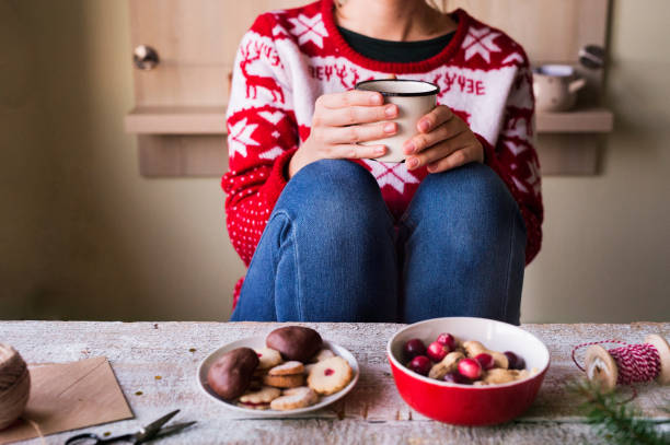 istock Unrecognizable woman drinking coffee at Christmas time. 875278124