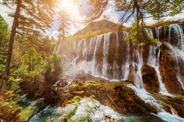 istock The Nuo Ri Lang Waterfall (Nuorilang) among fall woods 875281316