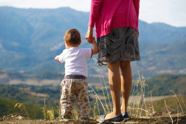 istock Mother with her baby looking at hills on the background 875283990