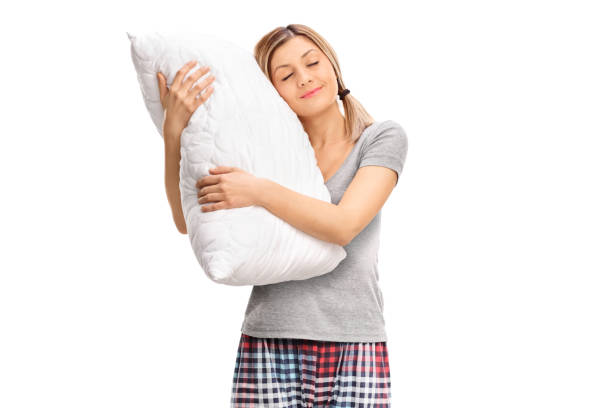 istock Woman in pajamas hugging a pillow 875284464