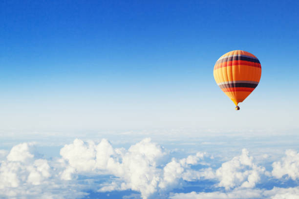 fond d’inspiration ou de voyage, ballon à air chaud au-dessus des nuages - blowing a balloon photos et images de collection