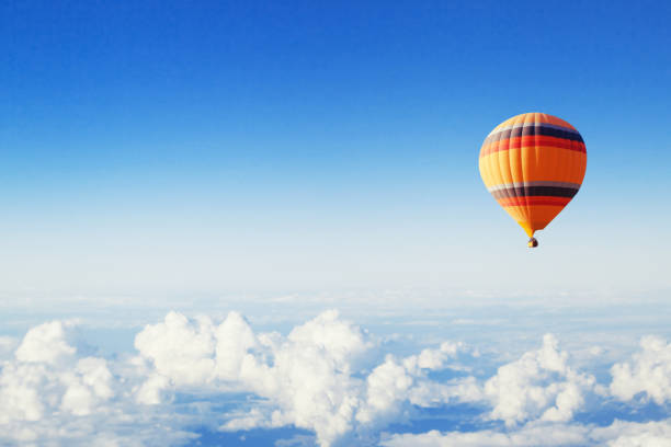 inspiration or travel background, hot air balloon over the clouds inspiration or travel background, fly above the clouds, colorful hot air balloon in blue sky hot air balloon stock pictures, royalty-free photos & images