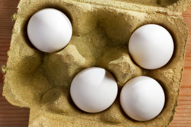 istock Four organic eggs in a box made of grass 875285704