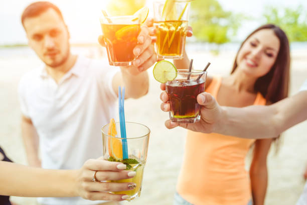 Friends having fun at the bar outdoors, drinking cocktails. Summer bar Sun flare