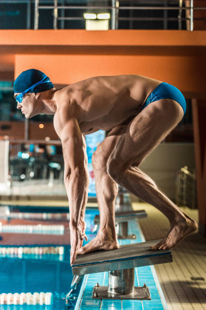 istock swimmer ready to jump into swimming pool 875297324