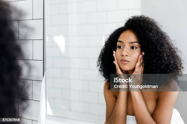 Photo libre de droit de Femme De Race Mixte Masser Son Visage Et En Regardant Un Miroir banque d'images et plus d'images libres de droit de Une seule femme