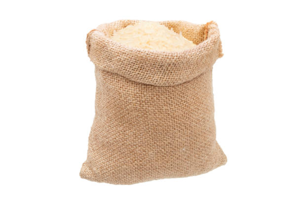 White rice in burlap sack bag isolated on white background