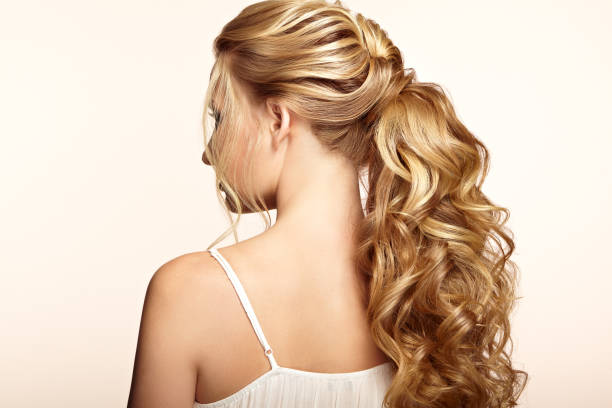 blonde girl with long and shiny curly hair - ponytail hairstyle female back imagens e fotografias de stock