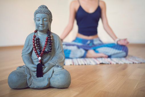 Beautiful handmade statuette of Lord Buddha is displayed in a shop for sale in blurred background. Indian art and handicraft.