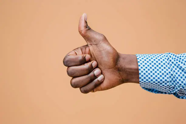 Photo of Hand showing OK sign isolated on brown background