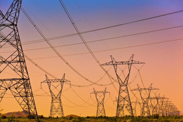 Electric Power Lines and Transmission Tower, Electric grid at sunset a Series of electrical transmission tower with power lines criss crossing at sunset. power cable photos stock pictures, royalty-free photos & images