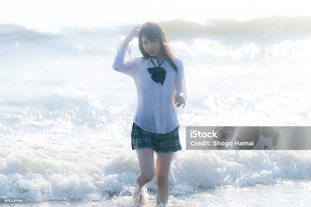 Schoolgirl on a beach Female senior high school student on a beach Beautiful People Stock Photo