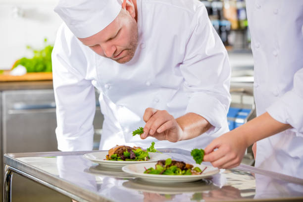 istock Two dedicated chefs prepares steak dish at gourmet restaurant 875340286