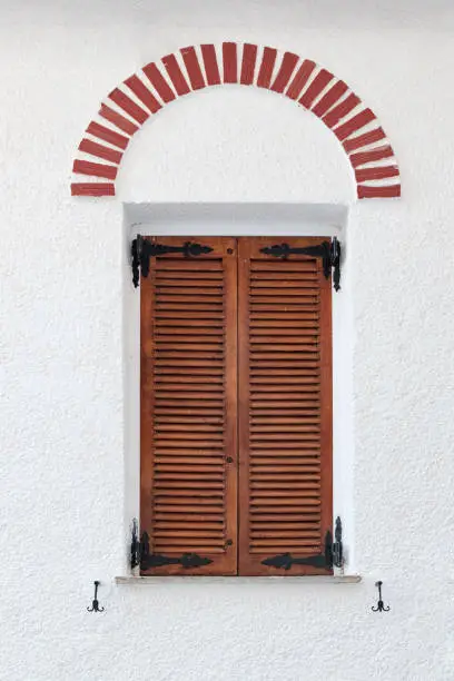 Photo of Greek wooden vintage window with brown shutters