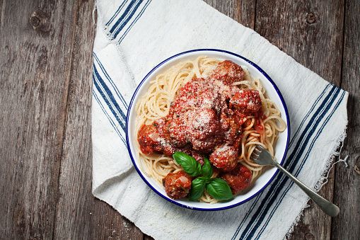 Spaghetti with meatballs and red sauce on wooden backfround