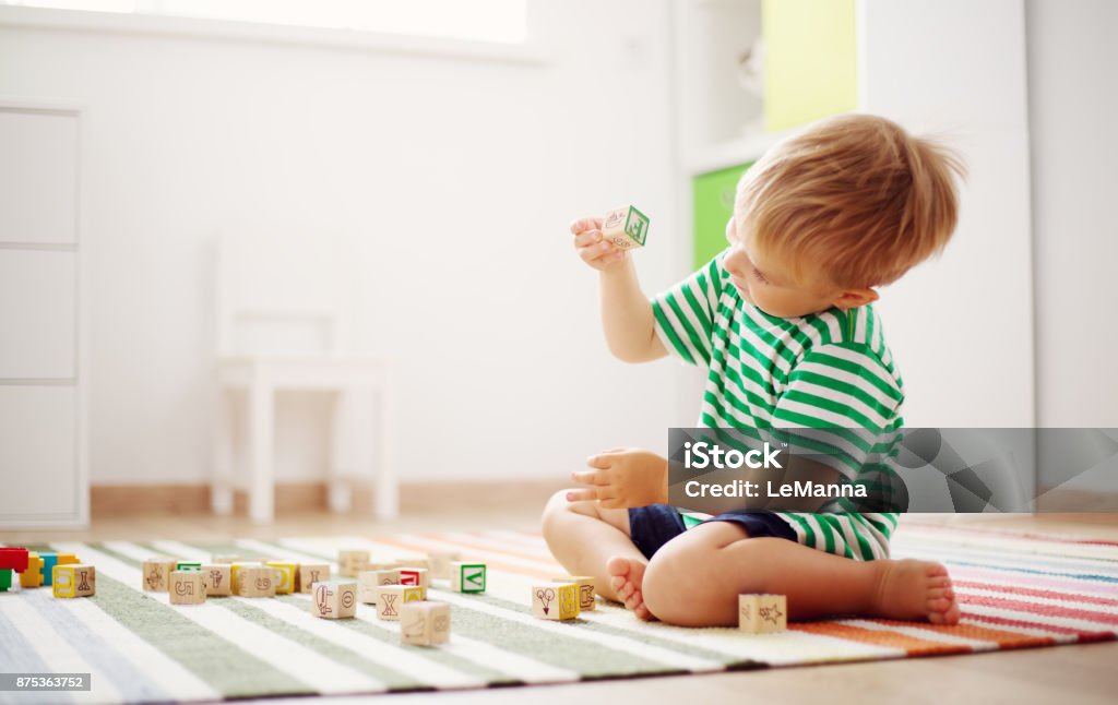 木製キューブで床に座っている 2 歳児 - 子供のロイヤリティフリーストックフ��ォト