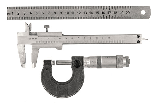 Three old measurement tools - ruler, caliper and  micrometer on white background