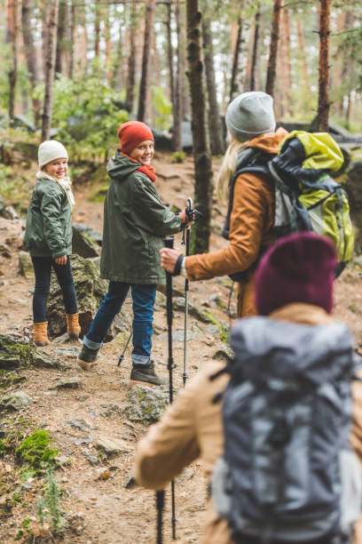 istock parents and kids trekking in forest 875375778
