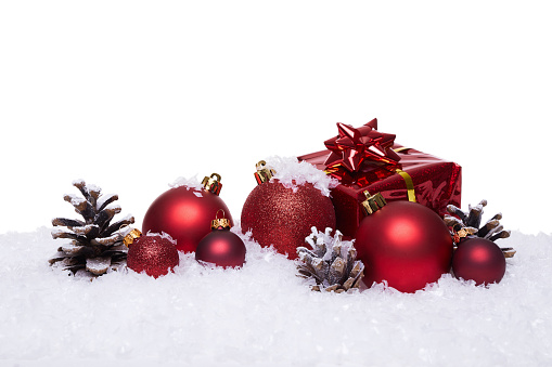 Christmas background with red balls on snow. Isolated on white