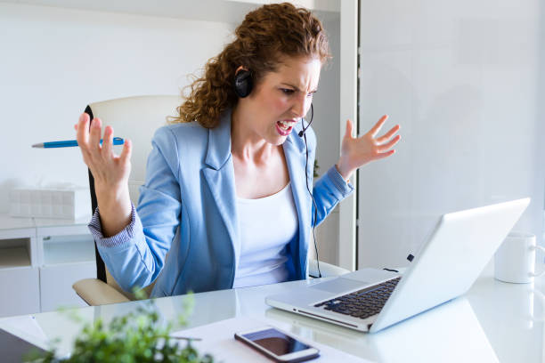 istock Angry customer service operator talking on phone in the office. 875382828