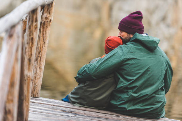istock father and son sitting on wooden bridge 875383158