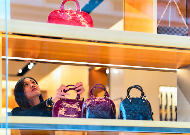헬싱키에 있는 루이 vuitton 상점에 손 가방을 선택 하는 여자 - vuitton 뉴스 사진 이미지