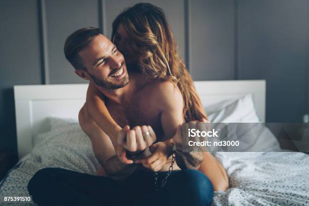Woman And Man Playing Domination Games In Bed Stock Photo - Download Image Now - Sexual Issues, Handcuffs, Leisure Games